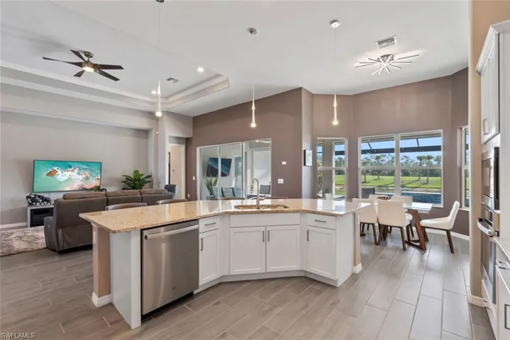 Kitchen featuring wood finish floors, a sink, stainless steel appliances, open floor plan, and visible vents