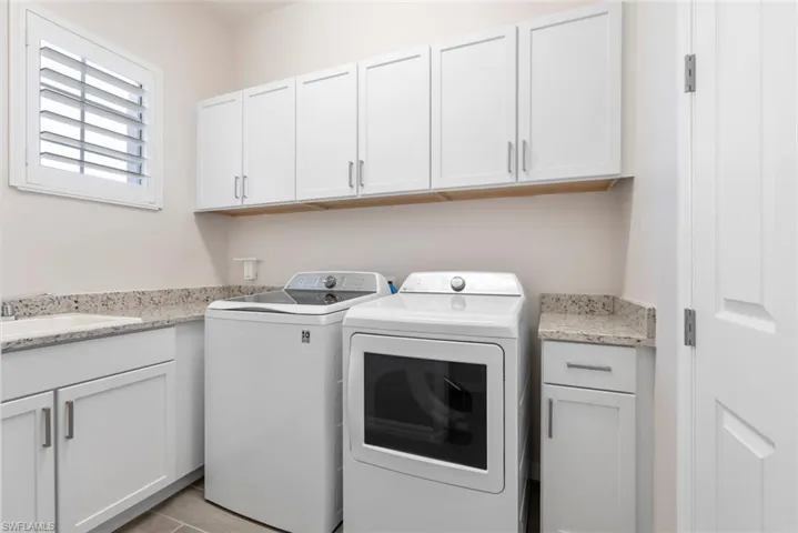 Laundry area with cabinet space, washer and clothes dryer, and a sink