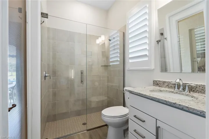 Full bath with vanity, a shower stall, and toilet