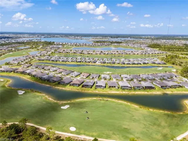 Aerial view featuring a water view, view of golf course, and a residential view