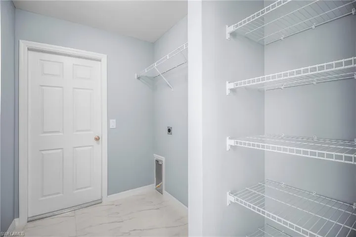 Laundry room with light marble finish flooring and hookup for an electric dryer