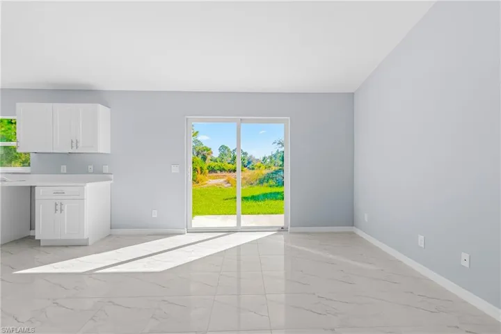 Unfurnished dining area with light marble finish floors and baseboards
