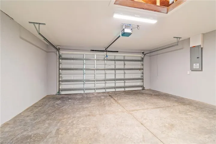 Garage with electric panel and a garage door opener