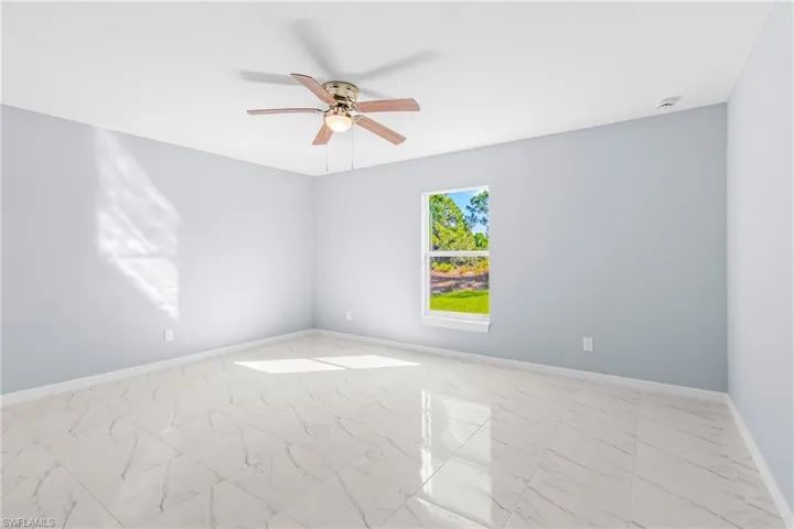 Unfurnished room with marble finish floors and a ceiling fan