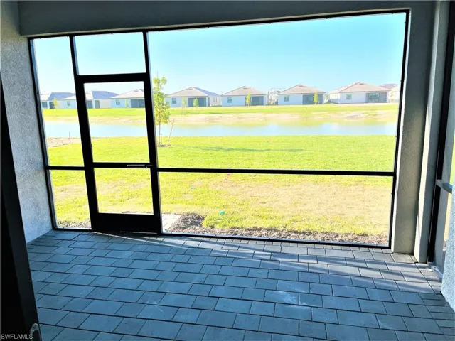 Unfurnished sunroom with a residential view and a water view