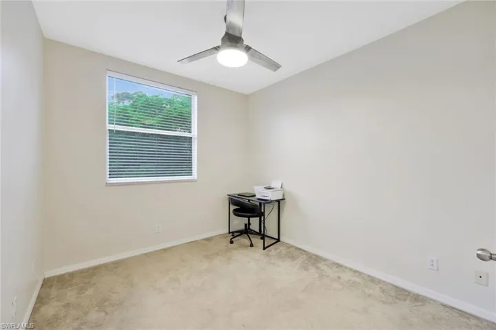 Empty room with ceiling fan and light colored carpet