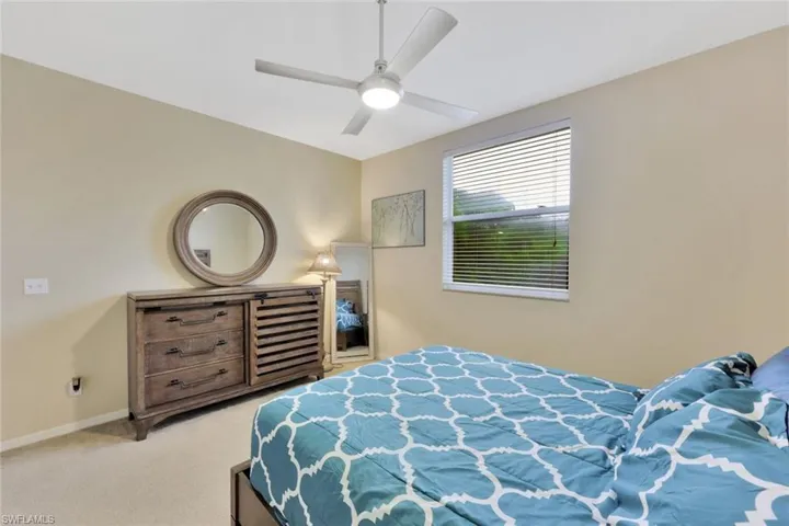Bedroom with ceiling fan and light colored carpet