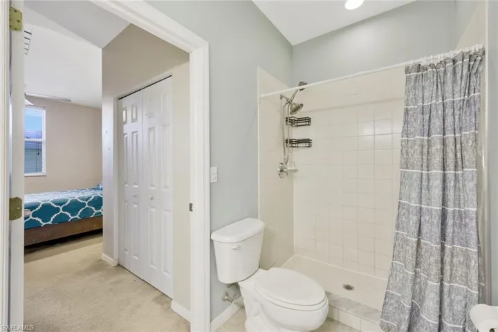 Bathroom with curtained shower and toilet