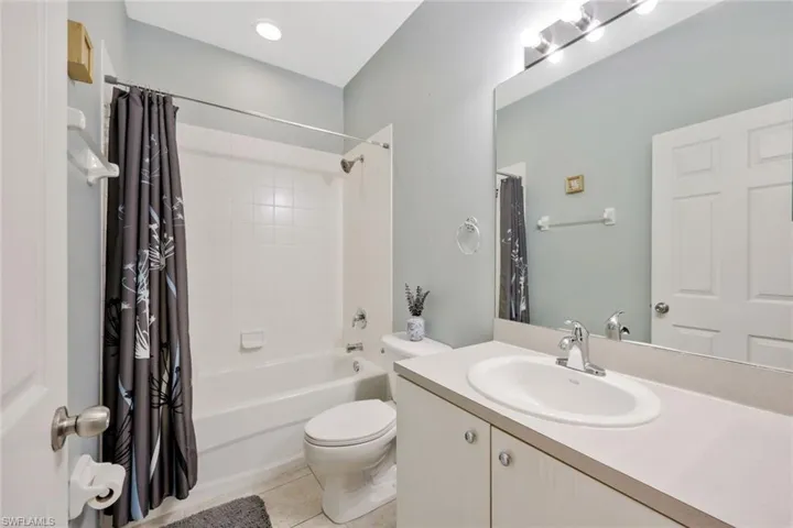 Full bathroom with tile flooring, vanity, toilet, and shower / tub combo