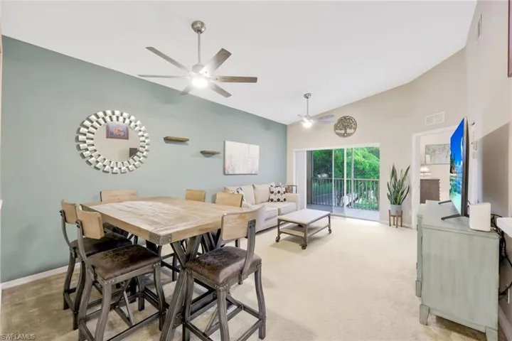 Dining room featuring high vaulted ceiling, ceiling fan, and carpet floors