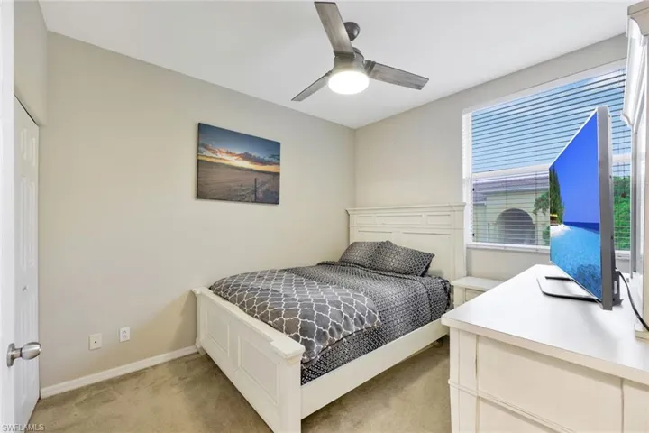 Carpeted bedroom with a closet and ceiling fan