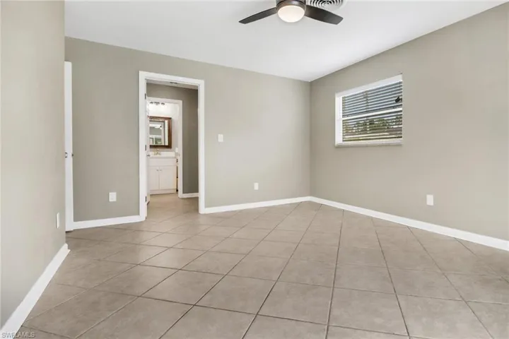 Spare room with ceiling fan and light tile patterned flooring