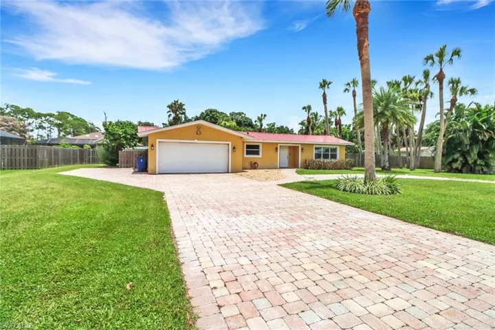Ranch-style home with a garage and a front lawn