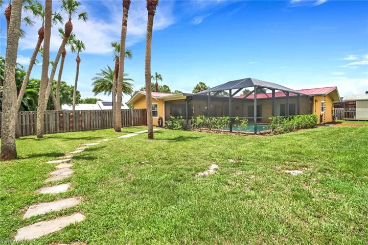 View of yard featuring glass enclosure and a pool