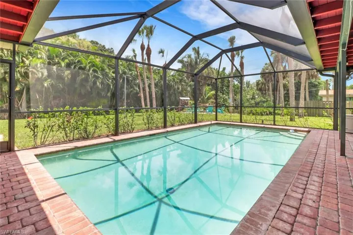 View of swimming pool featuring glass enclosure