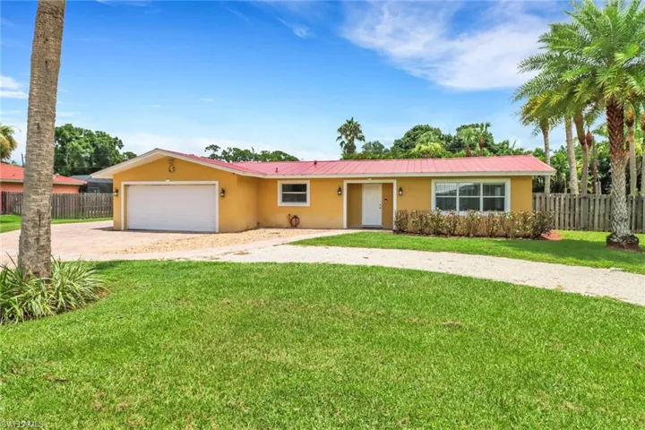Ranch-style home featuring a garage and a front lawn