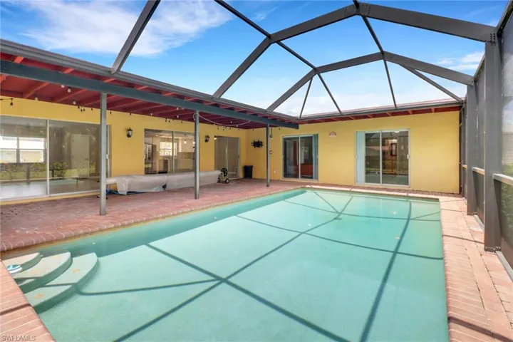View of pool with a patio area and a lanai