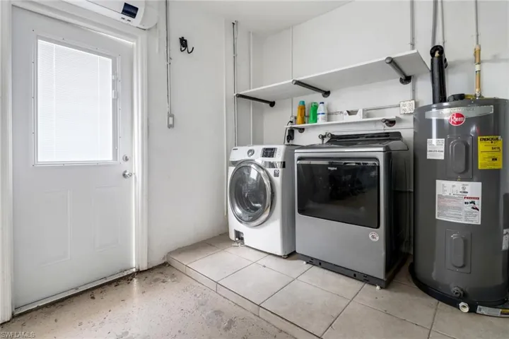 Laundry area featuring washing machine and clothes dryer and water heater