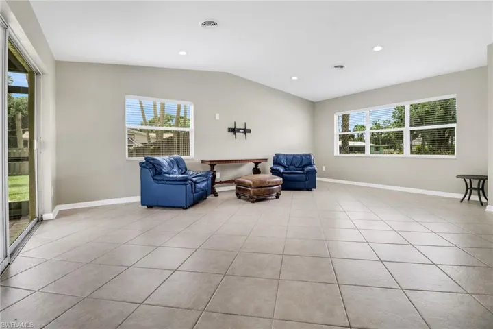 Living area featuring light tile patterned floors and lofted ceiling