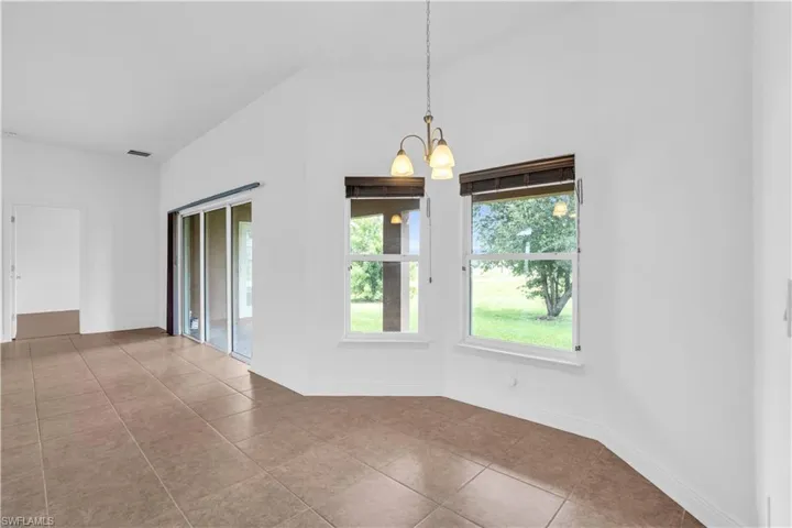 Spare room with an inviting chandelier and light tile patterned floors