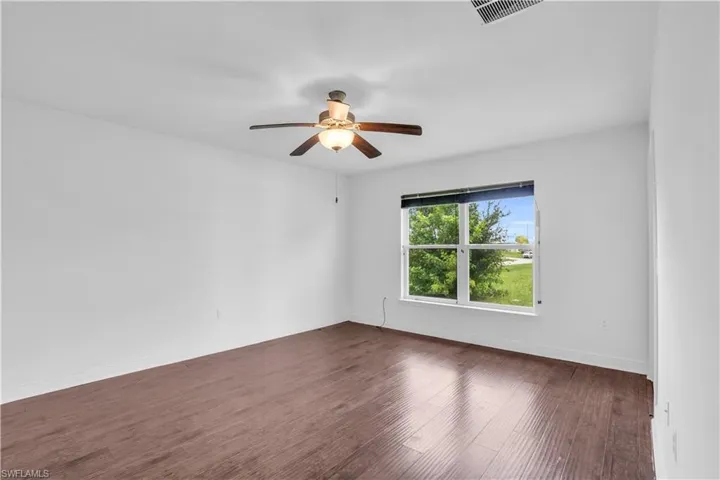 Unfurnished room featuring hardwood / wood-style floors and ceiling fan