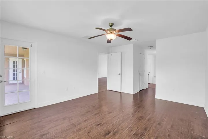Unfurnished room with ceiling fan and dark hardwood / wood-style floors