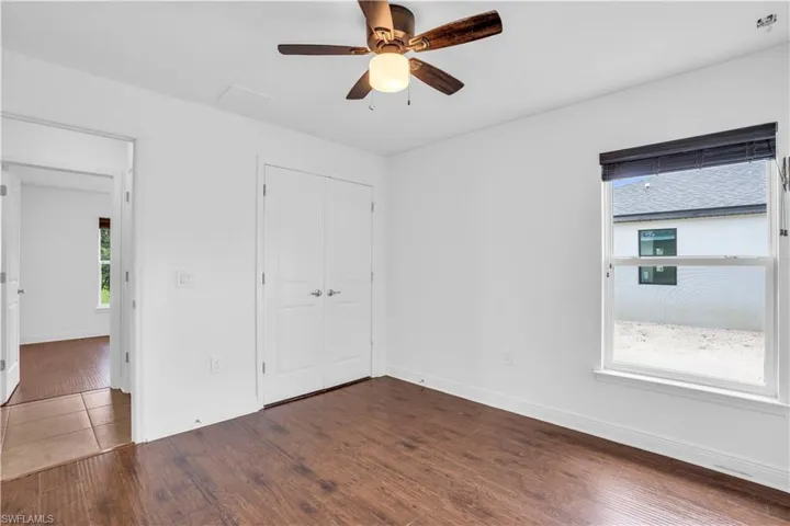 Unfurnished bedroom with a closet, hardwood / wood-style floors, and ceiling fan
