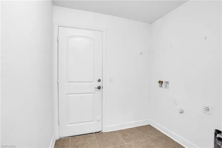 Laundry room featuring hookup for a gas dryer, light tile patterned floors, hookup for an electric dryer, and hookup for a washing machine