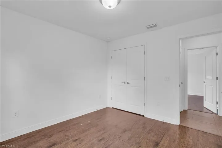 Unfurnished bedroom with a closet and wood-type flooring