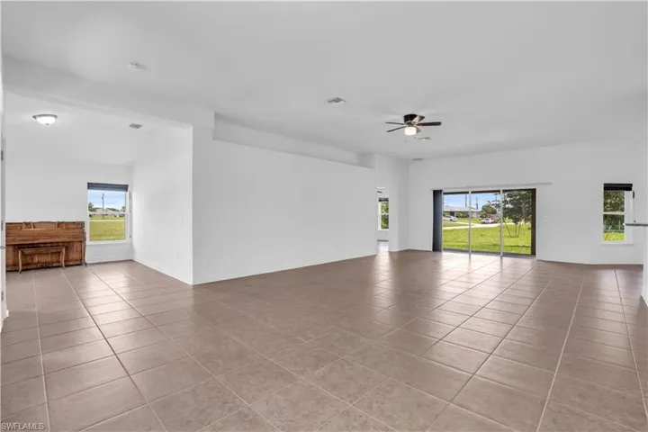 Unfurnished living room featuring ceiling fan and light tile patterned floors