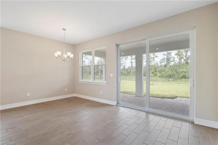 Unfurnished room with an inviting chandelier and light hardwood / wood-style flooring