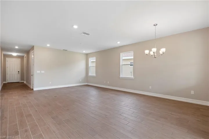 Unfurnished room with light hardwood / wood-style floors and an inviting chandelier