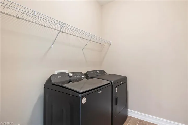 Laundry area with light hardwood / wood-style flooring and washer and dryer