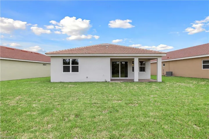 Rear view of house featuring a yard, a patio, and central air condition unit
