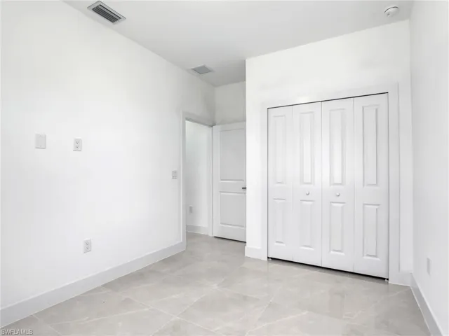 Unfurnished bedroom with light tile patterned floors and a closet