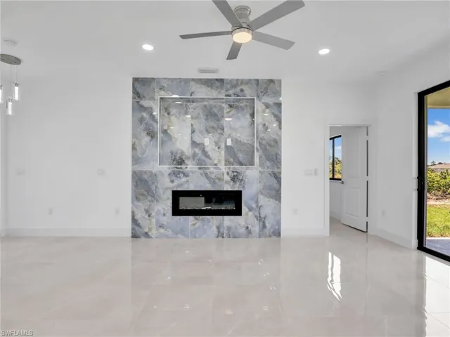 Unfurnished living room featuring a high end fireplace, ceiling fan, and recessed lighting