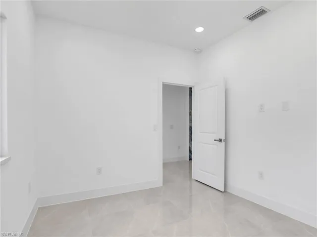 Empty room with recessed lighting and light tile patterned floors