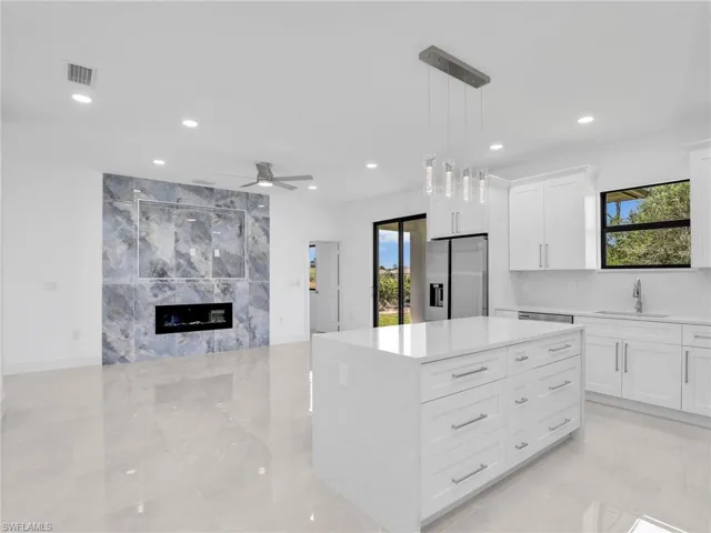 Kitchen with a center island, pendant lighting, healthy amount of natural light, white cabinets, and recessed lighting