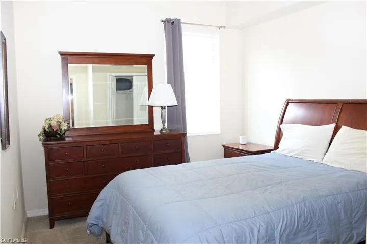 Bedroom with baseboards, carpet flooring, and multiple windows