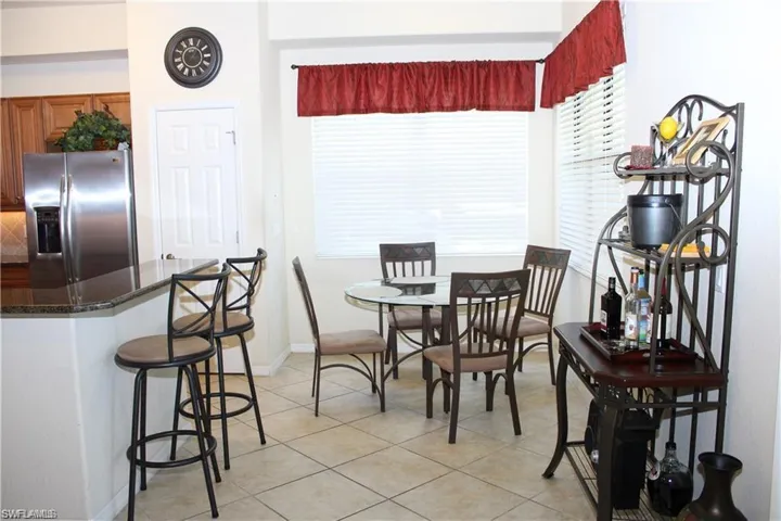 Dining area featuring light tile patterned floors and baseboards