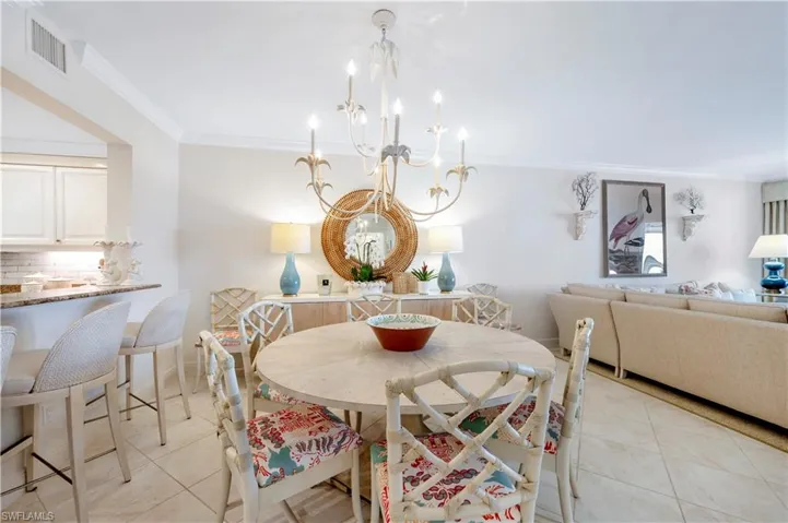 Dining room with a chandelier, ornamental molding, and light tile patterned flooring