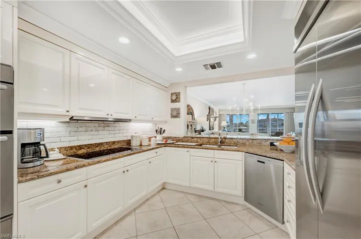 Kitchen featuring stone counters, white cabinetry, sink, and appliances with stainless steel finishes
