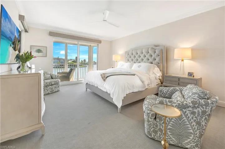 Carpeted bedroom featuring access to outside, ceiling fan, a water view, and ornamental molding