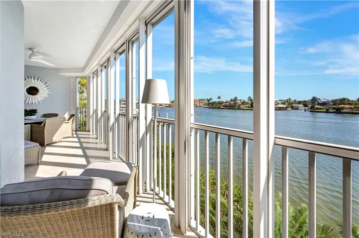 Sunroom / solarium with a water view and ceiling fan