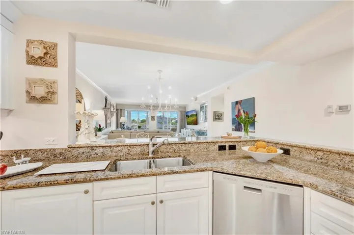 Kitchen with dishwasher, crown molding, sink, white cabinetry, and a chandelier