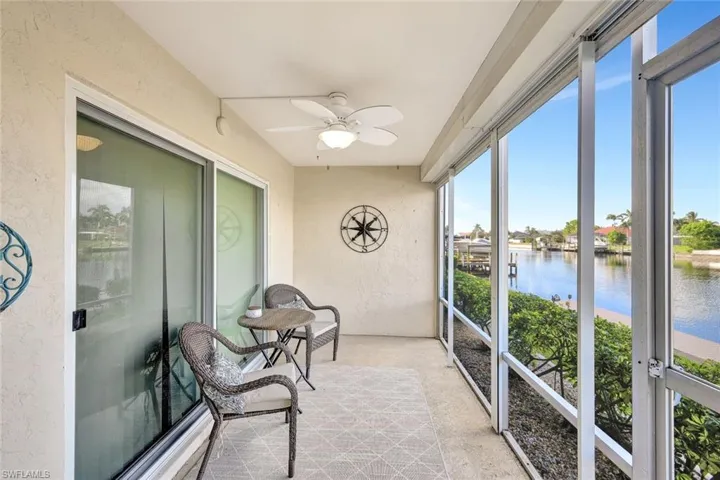 Sunroom / solarium with a water view and ceiling fan