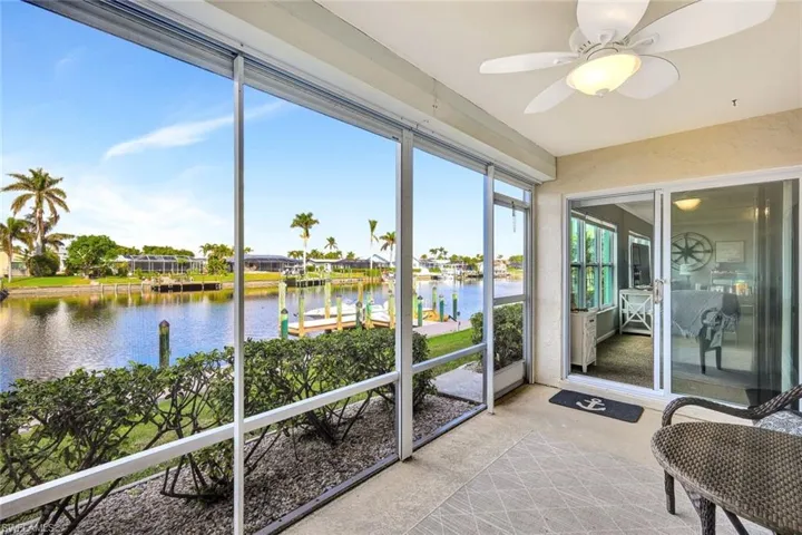 Sunroom featuring ceiling fan and a water view