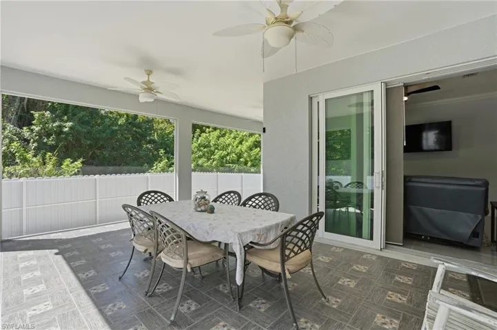 Sunroom with ceiling fan and outdoor dining space