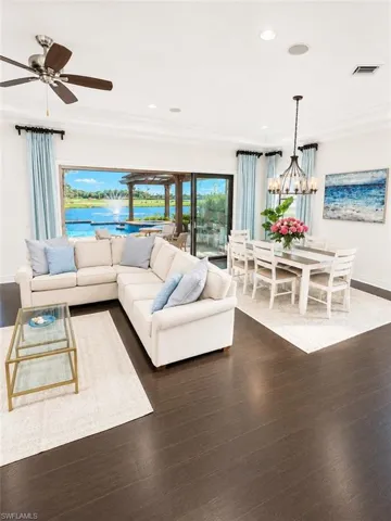 Expansive living area with dark wood-finish flooring, recessed lighting, and crown molding