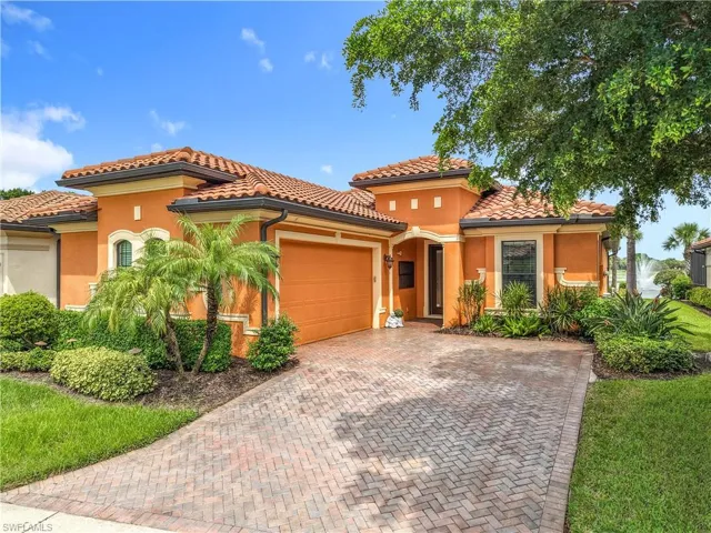 Mediterranean-style exterior featuring a terracotta tile roof, stucco finish, and an integrated garage